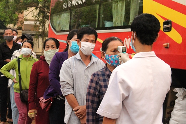 Cán bộ y tế đo thân nhiệt hành khách tại chốt kiểm dịch xã Hòa Phú- thành phố Buôn Ma Thuột